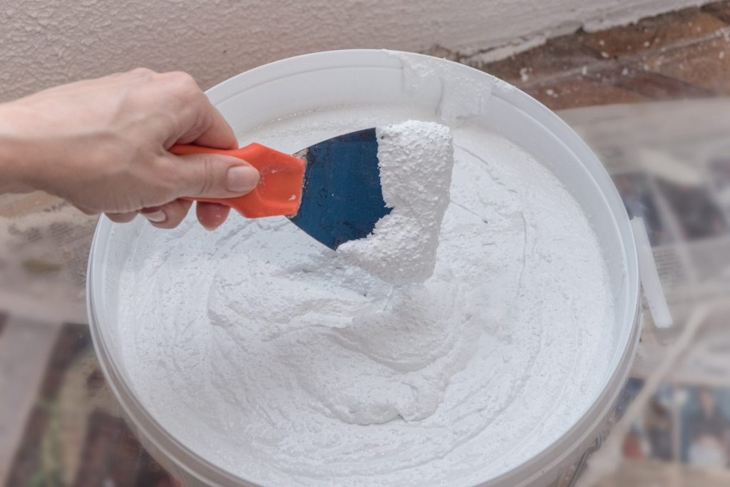 Preparing a wall with plaster patching before painting to get a home ready for sale